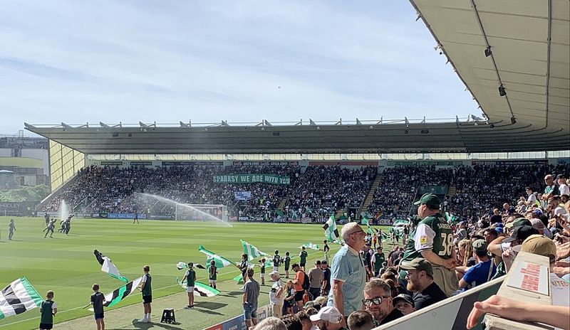 Plymouth Argyle fans at home page singling and waving flags and banners